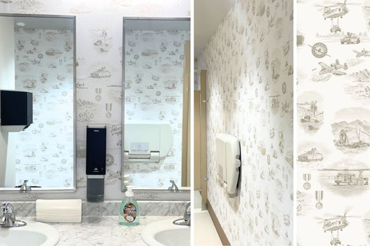 Custom military toile wallpaper by Pine + Feather Studio installed at the Warhawk Air Museum, with close-up detail of hand-illustrated motifs including CH-47 Chinook helicopter and military equipment