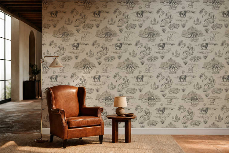 Pine + Feather Wild Yellowstone toile wallpaper in Gallatin Blue installed in a boutique hospitality reading nook — custom commercial-grade wallpaper styled with a warm leather wingback chair, brass floor lamp, and wood side table