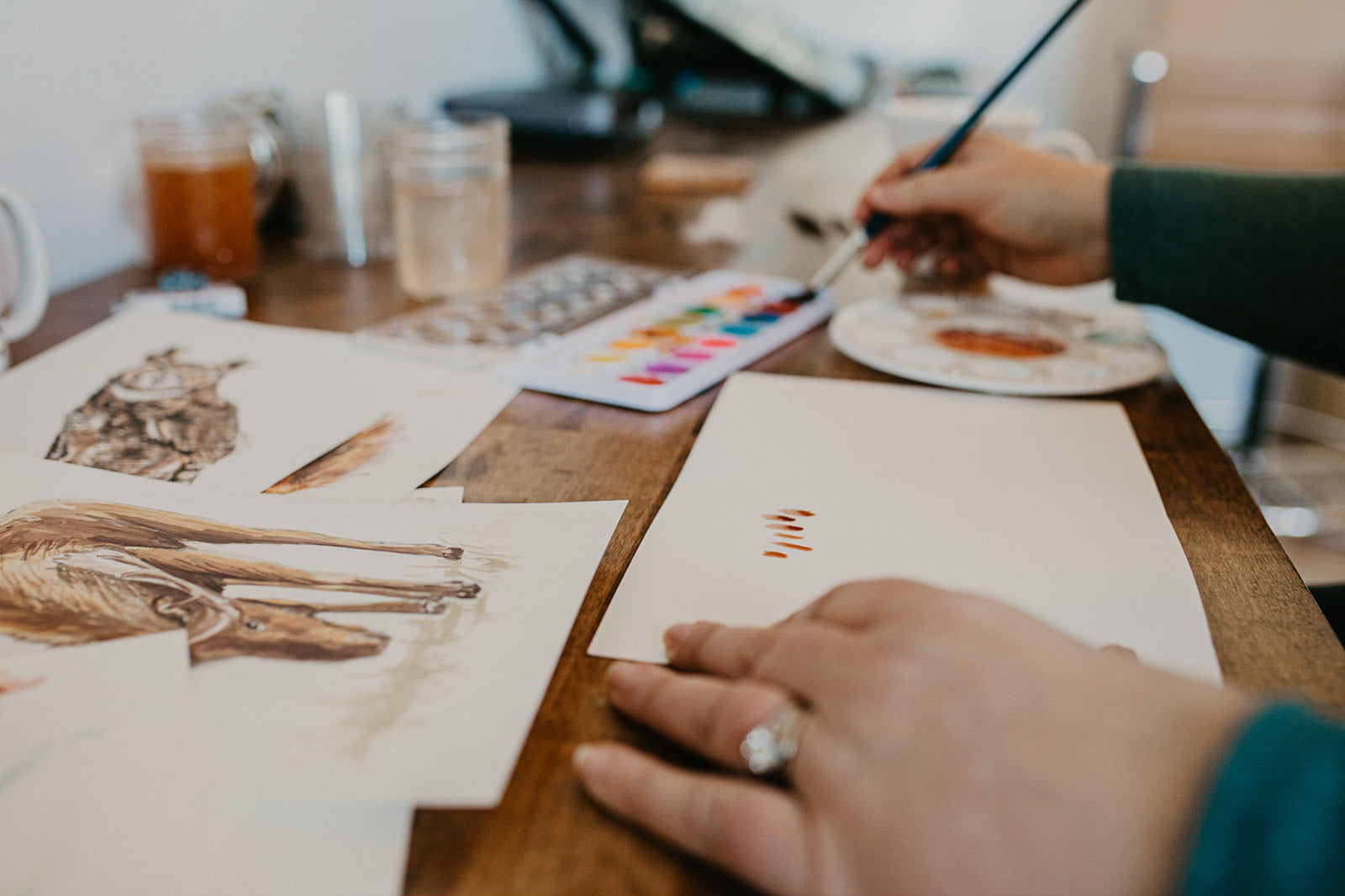 Stacie Humpherys painting watercolor nature illustrations at her studio desk — Pine + Feather Studio, Boise Idaho