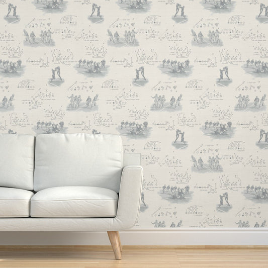 Vintage football wallpaper in pewter gray covering full accent wall behind a modern white sofa — pattern detail and scale