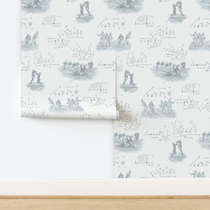 Vintage football wallpaper in pewter gray featuring hand-illustrated 1920s players and period play diagrams on warm off-white