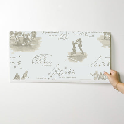 Wallpaper swatch showing vintage football playbook design in sepia — order before committing to full rolls