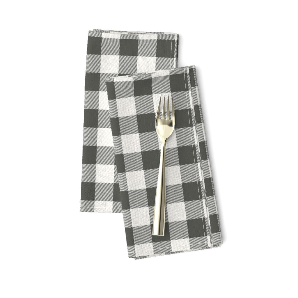 Cabin Check dinner napkins in Charcoal, a charcoal and cream buffalo check, folded on a white background