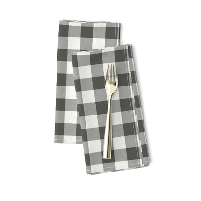 Cabin Check dinner napkins in Charcoal, a charcoal and cream buffalo check, folded on a white background