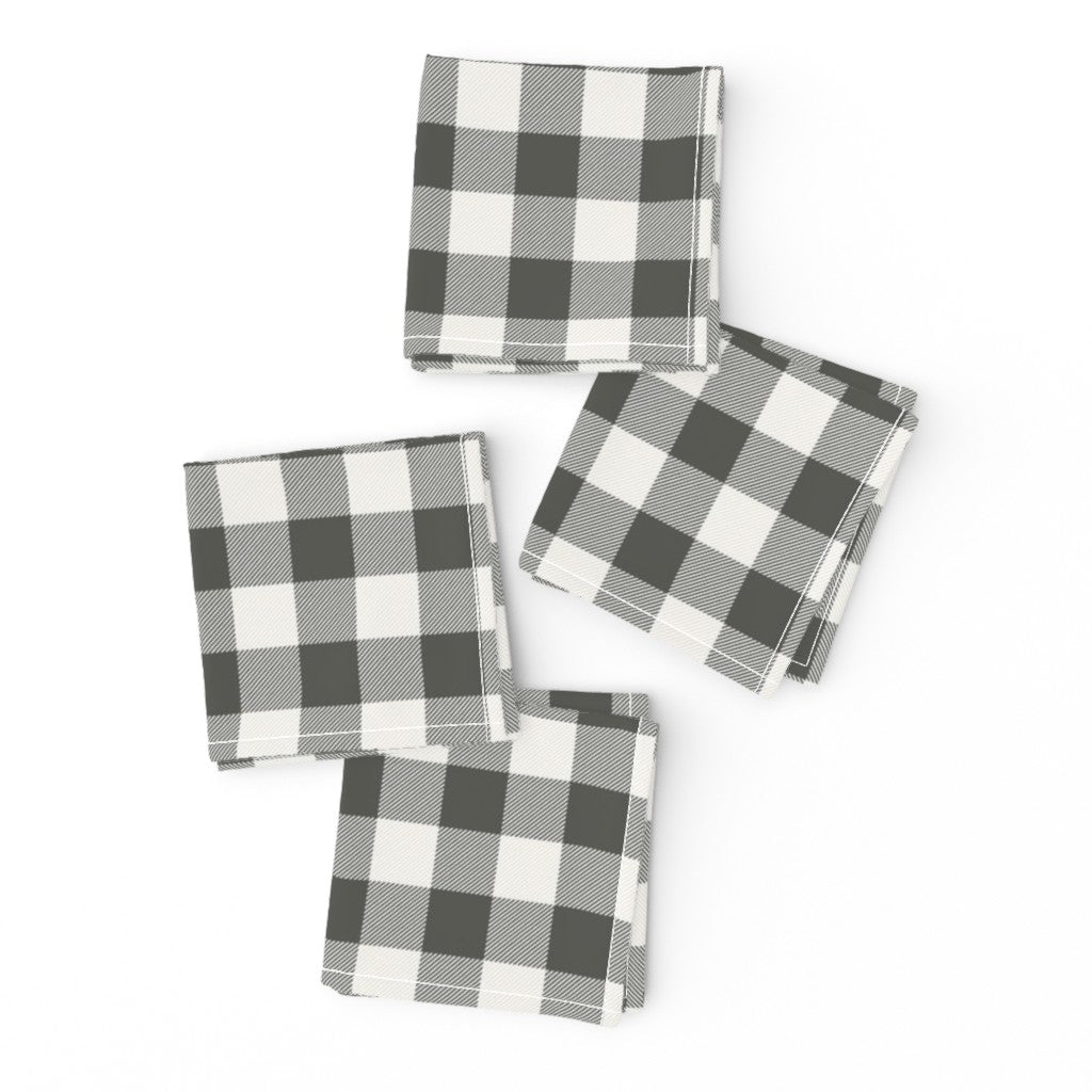 Two charcoal buffalo check cloth napkins folded and offset with a gold fork on top