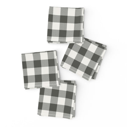 Two charcoal buffalo check cloth napkins folded and offset with a gold fork on top