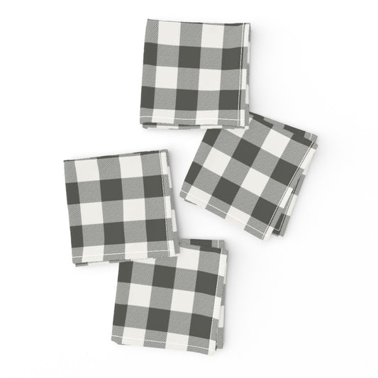 Two charcoal buffalo check cloth napkins folded and offset with a gold fork on top