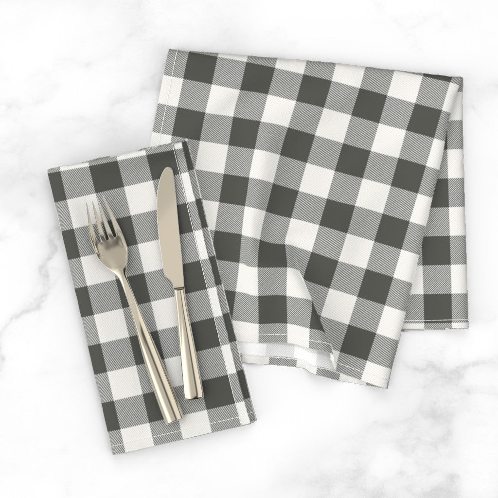 Charcoal buffalo check dinner napkin with a knife and fork on a white marble tabletop