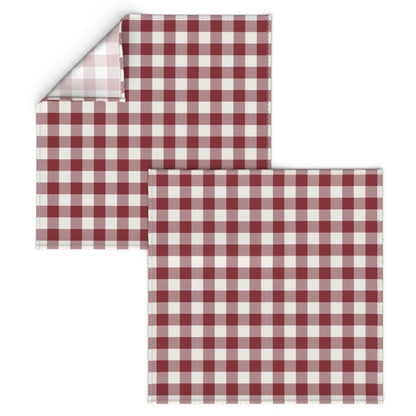 Corner of a red buffalo check napkin turned back to show the folded hem