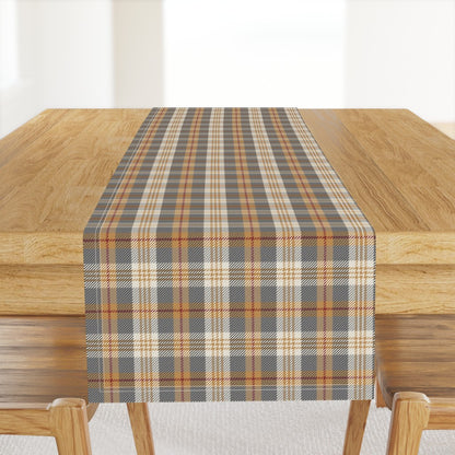 Homestead Plaid table runner in Winter Hearth, a charcoal and gold plaid, hanging off the end of a wood dining table