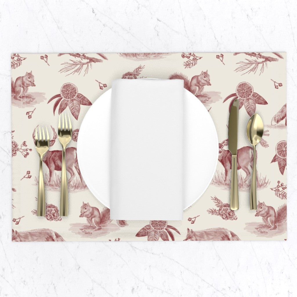 Cranberry woodland toile placemat set with a white plate, napkin and gold flatware on a marble table